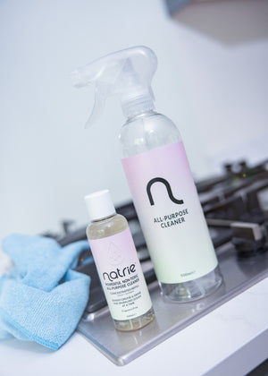 Two bottles of Natiie all-purpose cleaner on a kitchen counter with a blue towel.